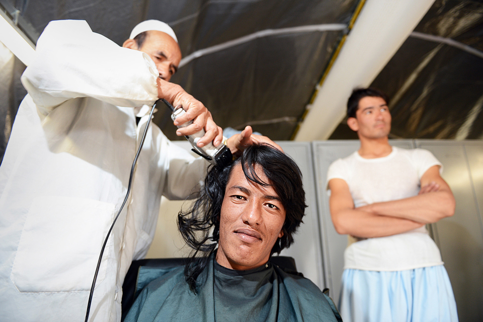 An officer cadet has his hair cut on day one of his training