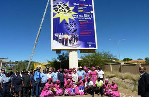 NamPol IGP Lt General S. Ndeitunga with High Commissioner M. Young, with a group of police officers underneath the billboard