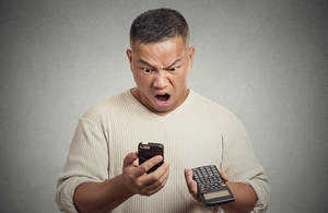 Man looking shocked after seeing mobile phone bill