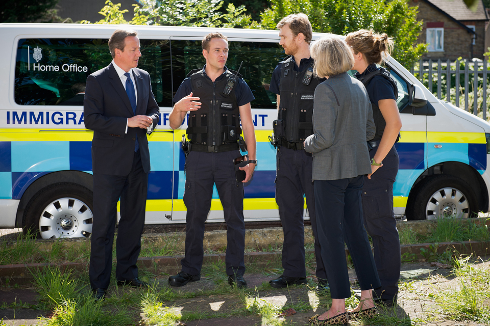 Immigration officers explain their roles to David Cameron and Theresa May.