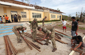 Service personnel working to repair the roof of Bitoon elementary school on Calagnaan island [Picture: Darren Fletcher Photography Limited]