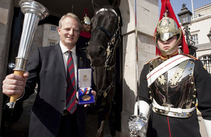 Former Guards Officer and Olympic Pentathlete, Dominic Mahony, displays the Bronze medal he won at Seoul in 1988, and an authentic Olympic torch outside Horse Guards, where an Olympic exhibition has opened