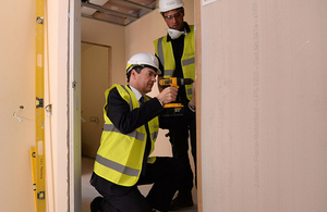 Chancellor drilling a hinge on a door