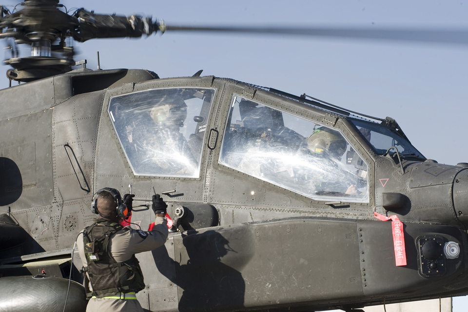 A ground crew member showing pilots the pins from missiles