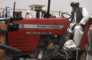District Governor Habibullah Khan starts up the first tractor just outside Forward Operating Base Shawqat in the district centre of Nad 'Ali