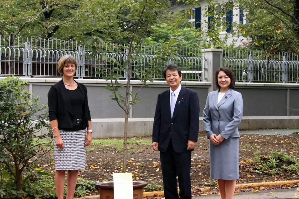 State Minister Miyashita and Chargé d’Affaires Longbottom posed for a photo with a taihaku cherry tree planted by HRH The Duke of Cambridge during his first visit to Japan in February 2015.