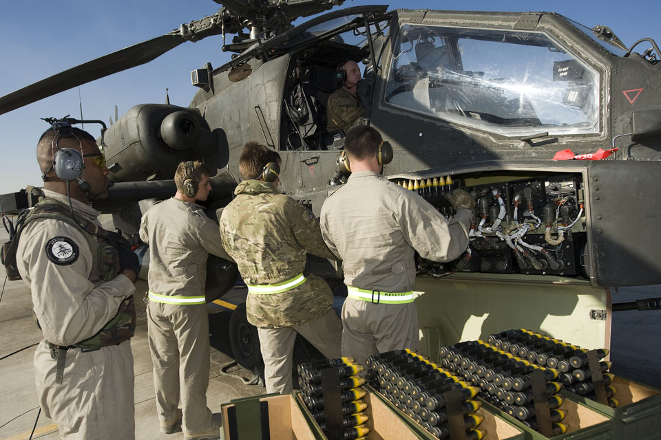 Ground crew reload ammunition onto an Apache