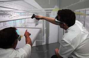 Two men wearing digital viewers to plan a factory project in a 3D visualisation suite