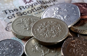 Pound coins along with Scottish bank note