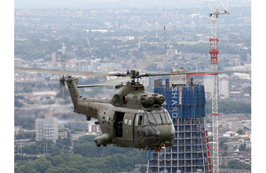 A Royal Air Force Puma HC1 helicopter from 230 Squadron, based at RAF Benson in Oxfordshire, is pictured flying past the construction site of 'The Shard' skyscraper during a training flight over London