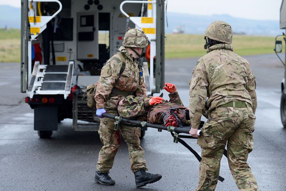 Commandos transporting a simulated casualty to a waiting ambulance