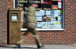 A soldier walks past the gold-painted postbo
