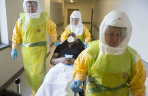 Medical personnel in protective clothing treating a patient