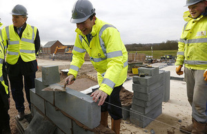 Chancellor laying a brick on a building site