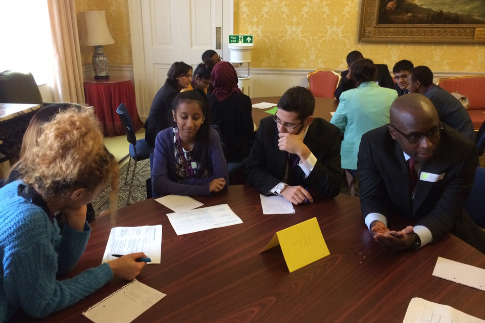 Students sitting around tables in discussion.