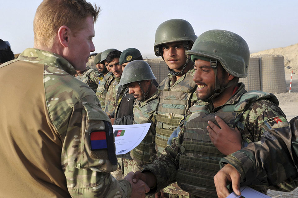 A British officer awards Afghan National Army Gunners with certificates on completion of their training 