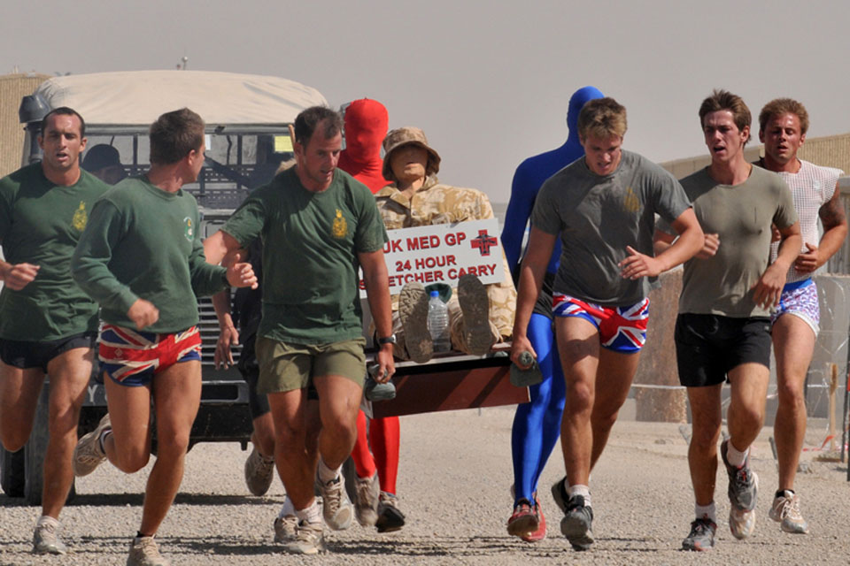 Royal Marines wearing fancy dress taking part in the stretcher-carry around Camp Bastion