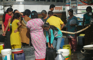 Nepalese people affected by flash flooding of the Seti River gather to collect fresh water provided by the British Gurkha Camp in Pokhara