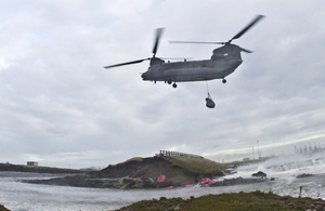 An 18 Squadron RAF Chinook moving bags of aggregate into breached sea defences [Picture: Corporal Jimmy Wise RAF, Crown copyright]