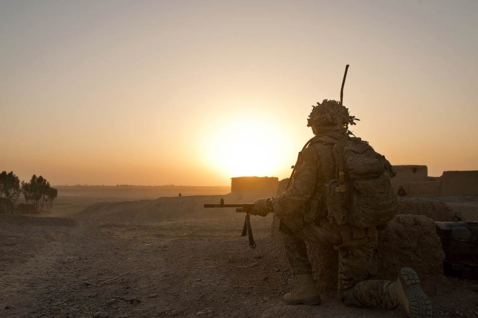 A soldier of 5 RIFLES kneels near the end of a patrol in Helmand, Afghanistan.
