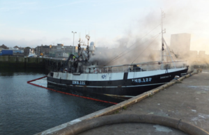 Photograph of fishing vessel Ardent II on fire while alongside