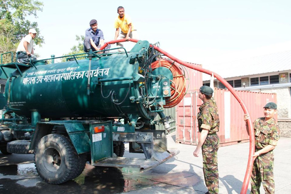 Gurkha soldiers at the British Gurkha Camp in Pokhara fill a local authority water tanker to help local Nepalese people affected by flash flooding of the Seti River