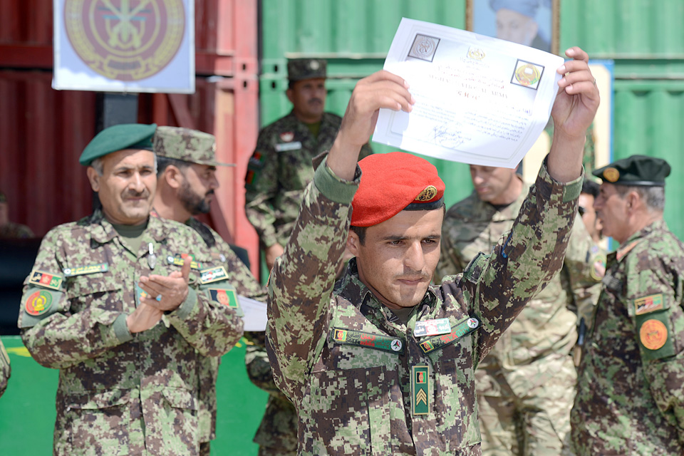 An Afghan soldier proudly displays a certificate