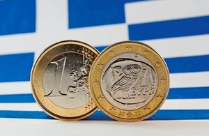 Image of the Greek flag and euro coins. [©istock.com/ikholwadia]