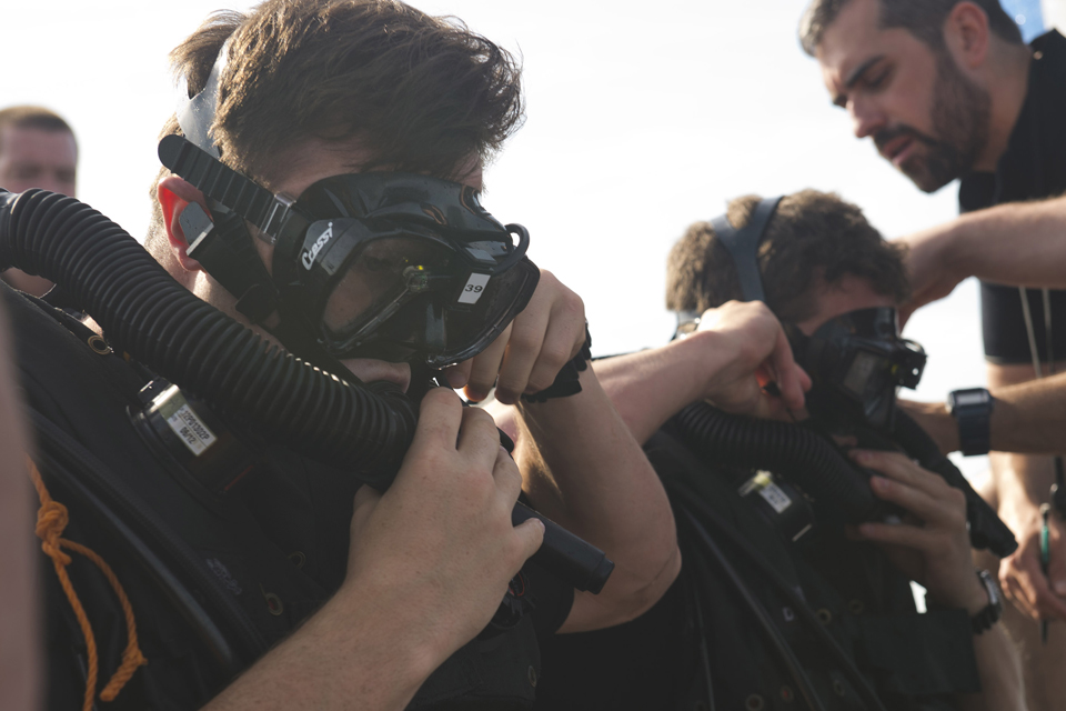 Divers don their gear in preparation for a dive 