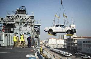 Pickup trucks are loaded onto the RFA Argus. Picture: Crown Copyright 2014