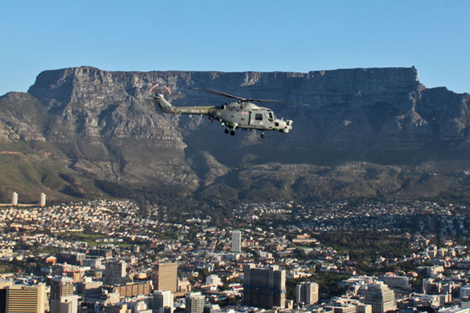 HMS Edinburgh's Lynx flies past Table Mountain in Cape Town