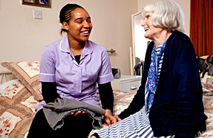 A carer with an older person in a residential care home