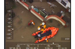 The crew of RAF Valley Sea King Search and Rescue helicopter Rescue 122 assisting members of the Borth lifeboat team who had become caught in debris while searching for trapped persons following severe flooding in western Wales