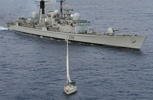 HMS Gloucester alongside the yacht Tortuga in the Atlantic Ocean