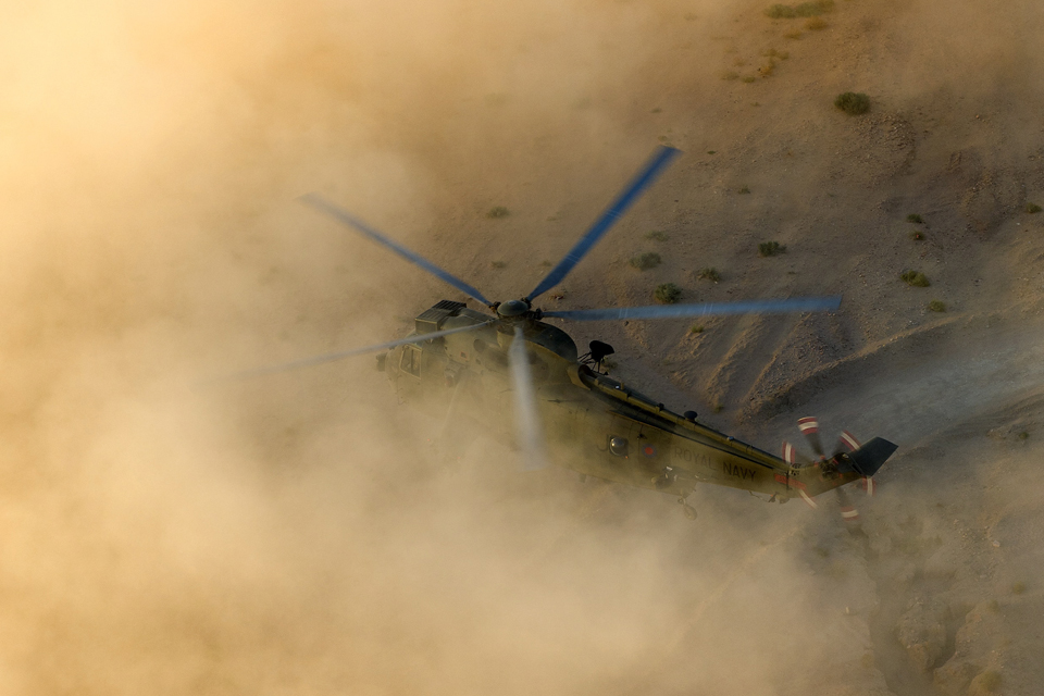 A Sea King helicopter practises landing in a dust cloud