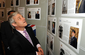 The Speaker of the House of Commons, John Bercow, views a display of 'Then & Now' images of armed forces veterans who now work within the parliament community