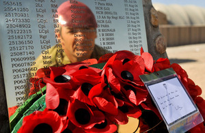 The reflection of a British soldier in one of the plaques on the Camp Bastion Memorial to the members of Her Majesty's Armed Forces who have lost their lives during military operations in Afghanistan