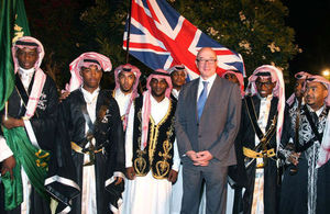 السفير البريطاني لدى السعودية، السير جون جينكيز، مع مجموعة سعودية تؤدي رقصة "العرضة"