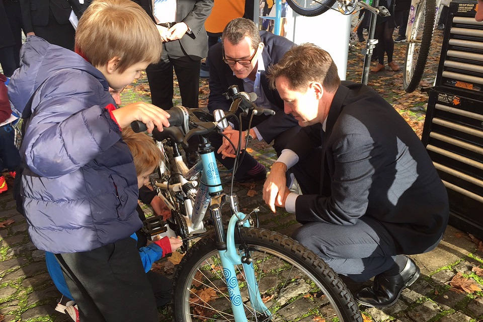 Nick Clegg, Halfords CEO Matt Davies & school children learning to maintain new bikes.