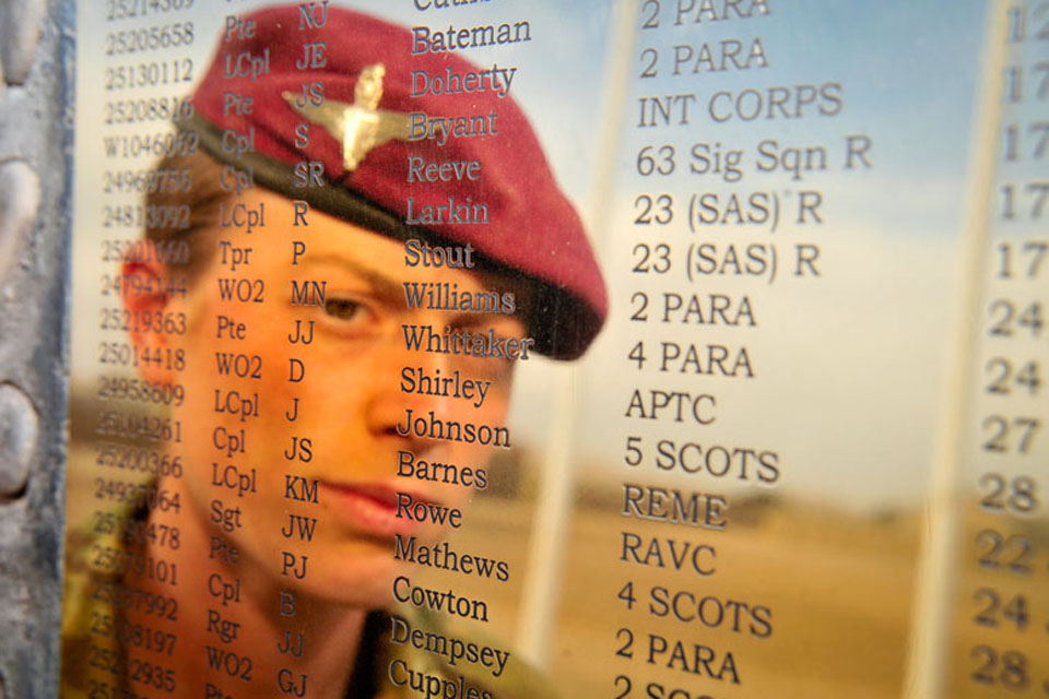 Musician Kate Whittaker reflected in the plaque on the Helmand Memorial Stone at Camp Bastion