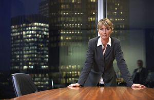 Business woman standing at Board table in a corporate office