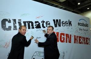 Secretary of State Edwards Davey signing the Climate Week 'pledge wall' at Ecobuild