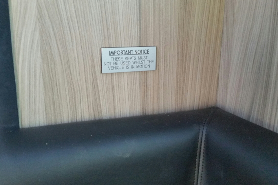 A sign stating that these seats must not be used whilst the vehicle is in motion.