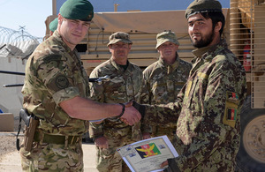 A newly-qualified Afghan explosives expert is congratulated by his British mentor [Picture: Leading Airman (Photographer) Rhys O'Leary, Crown copyright]