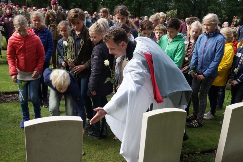 Local school children from Oosterbeek lay flowers on LCpl Loney’s grave with the assistance of Reverend Dr Brutus Green, Crown Copyright, All Rights Reserved