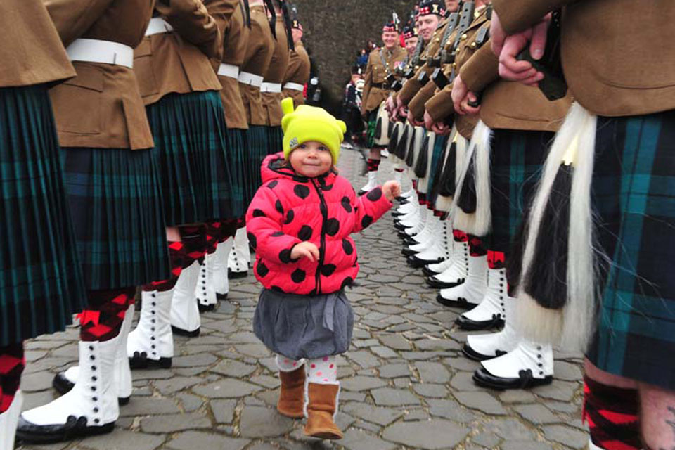 Two-year-old Hania Nowak from Poland 'inspects' the troops of the Royal Regiment of Scotland during her visit to Stirling Castle with her parents
