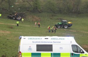 The farmer who was trapped beneath his overturned tractor being stretchered to the waiting ambulance for transfer to Gannet's Sea King helicopter