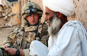 Sergeant Wayne Jackson Royal Marines, a troop sergeant with Mike Company, 42 Commando, talks with a local man during Operation ZAMROD OLAI in northern Nad 'Ali, Helmand province