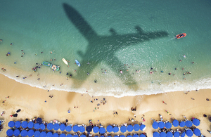 Beach scene with shadow of an aircraft.