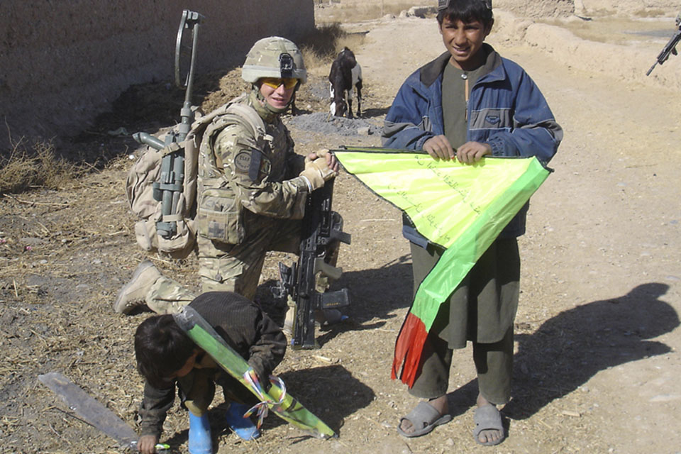 A soldier from 2nd Battalion The Royal Regiment of Scotland with local Afghan children and their new kites